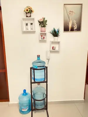 a shelf filled with blue water bottles in a room at 13 de las Americas in La Alianza