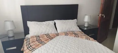 a bed with a black head board and two lamps at 13 de las Americas in La Alianza