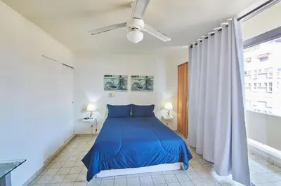 a blue bed in a white room with a window at Modern Santo Domingo Condo in Heart of Gazcue in Santo Domingo