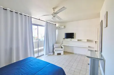 a bedroom with a bed and a chair and a window at Modern Santo Domingo Condo in Heart of Gazcue in Santo Domingo