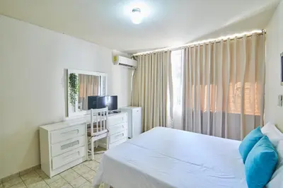 a bedroom with a bed and a desk and a television at Modern Santo Domingo Condo in Heart of Gazcue in Santo Domingo