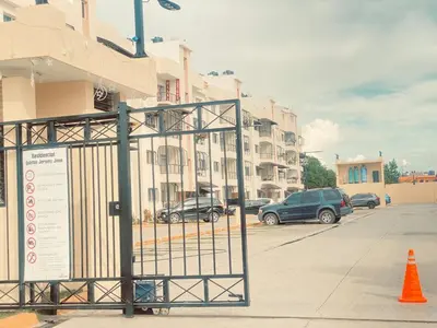 a gate in a parking lot next to a building at 13 de las Américas in La Alianza