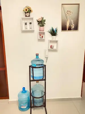 a shelf filled with water bottles in front of a wall at 13 de las Américas in La Alianza