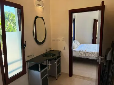 a bathroom with a sink and a mirror and a bed at Okaina 7 Penthouse in Cabarete