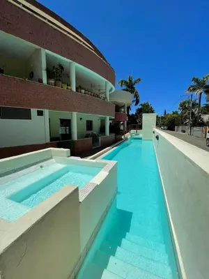 a swimming pool in front of a building at Okaina 7 Penthouse in Cabarete