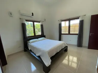 a bedroom with a bed and two windows at Okaina 7 Penthouse in Cabarete