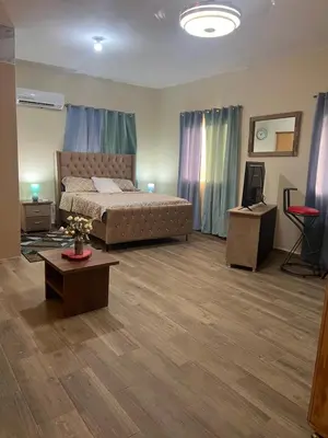 a bedroom with a bed and a table in a room at Hostal Bless house in San Pedro de Macorís