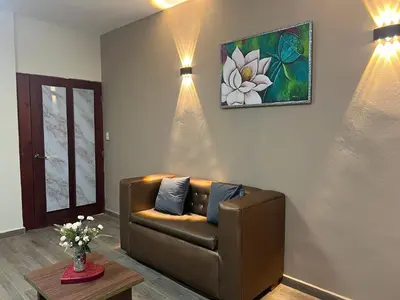 a living room with a couch and a painting on the wall at Hostal Bless house in San Pedro de Macorís