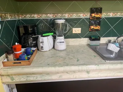 a kitchen counter with a blender and a sink at Hostal Bless house in San Pedro de Macorís