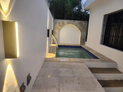a swimming pool next to a building with a house at Mila's House in La Romana
