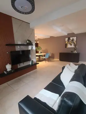 a living room with a couch and a flat screen tv at Mila's House in La Romana