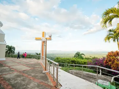 a cross at the top of a hill with people walking at Ketsys Home Near Santo Cerro in Concepción de La Vega