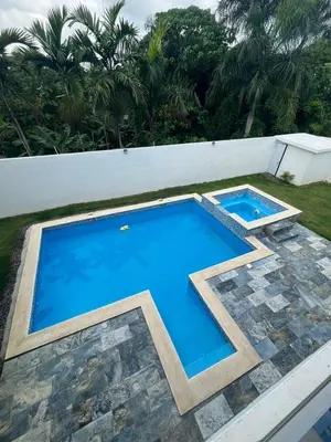 a large swimming pool sitting next to a white wall at VillaGuerra-Piscina-Billar-BBQ-WiFi-Cozy-3Br-5Bds-7Pax in Guerra