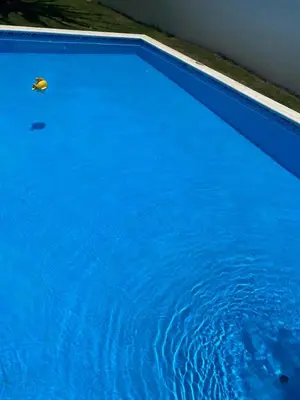 a blue swimming pool with a yellow object in the water at VillaGuerra-Piscina-Billar-BBQ-WiFi-Cozy-3Br-5Bds-7Pax in Guerra