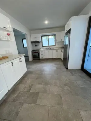 a large kitchen with white cabinets and a tile floor at VillaGuerra-Piscina-Billar-BBQ-WiFi-Cozy-3Br-5Bds-7Pax in Guerra