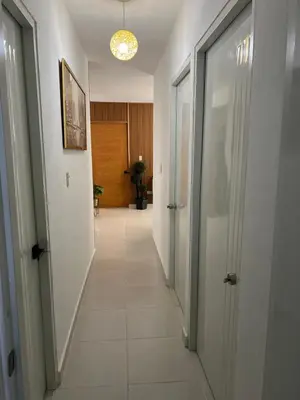a hallway with white walls and a hallway with doors at Hermoso y amplio apartamento de 3 habitaciones y 2 baños ! in San Pedro de Macorís
