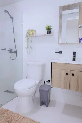 a white bathroom with a toilet and a sink at Hermoso y amplio apartamento de 3 habitaciones y 2 baños ! in San Pedro de Macorís