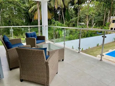 a patio with wicker chairs and a swimming pool at Brandnew 3 BR villa in Cabarete in Cabarete