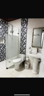a bathroom with a toilet and a sink and a shower at Villa Jarabacoa in Concepción de La Vega