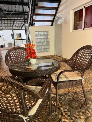 a glass table with two chairs and a vase with flowers at Villa Jarabacoa in Concepción de La Vega