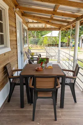 a wooden table and chairs on a porch at Casa Palma El Limon Samana in El Limón