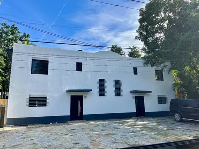 a white building with black doors and windows at Villa Valentina Cabarete Procab in Cabarete