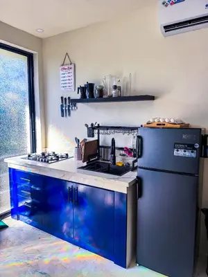 a kitchen with blue cabinets and a refrigerator at Kaleidoscopic Apartment in La Majagua