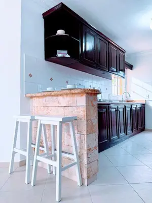 a kitchen with a brick counter and white stools at Rooftop, Pool View, Walk to Beach, Dining, Shops in Punta Cana