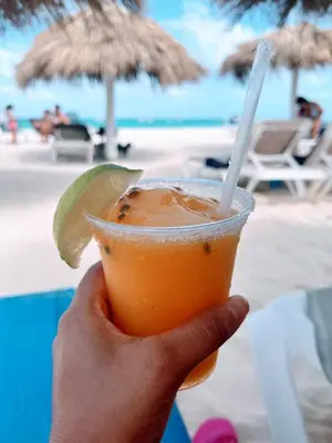a hand holding a drink with a lime on the beach at Rooftop, Pool View, Walk to Beach, Dining, Shops in Punta Cana