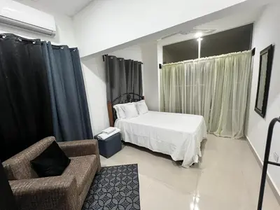 a bedroom with a bed and a chair and a couch at The Omelís House in Santa Bárbara de Samaná
