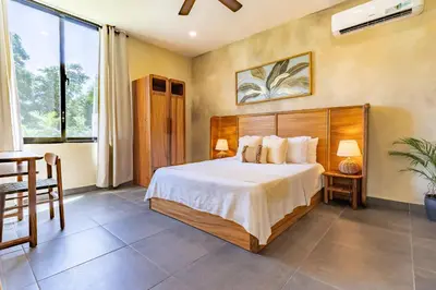 a bedroom with a bed and a table and a window at VillaVida Boutique Hotel - La Playita in Las Galeras