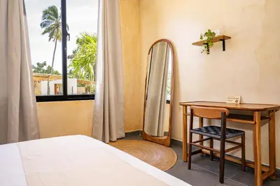 a bedroom with a desk and a bed and a window at VillaVida Boutique Hotel - La Playita in Las Galeras