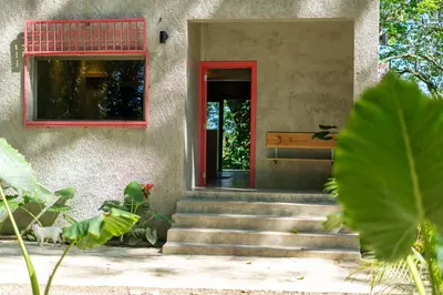 a house with a red door and stairs at REFUGIO Nature meets Luxury in Sabaneta de Yásica