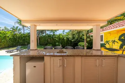 an outdoor kitchen with a sink and a pool at Casa Linda Villa 918 - Sosua in Sosúa