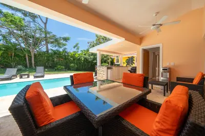 a living room with a table and chairs and a pool at Casa Linda Villa 918 - Sosua in Sosúa