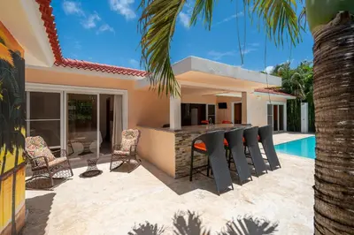 a patio with a bar and chairs next to a house at Casa Linda Villa 918 - Sosua in Sosúa