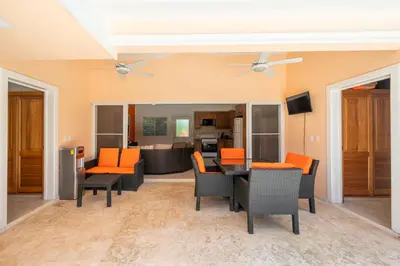 an open living room with orange chairs and a table at Casa Linda Villa 918 - Sosua in Sosúa