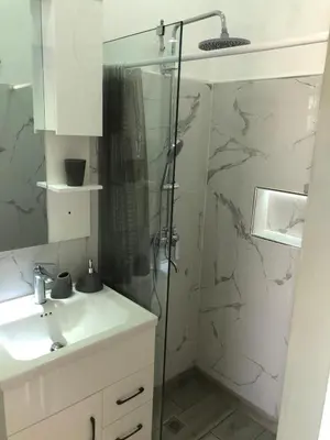 a white bathroom with a shower and a sink at Bayahibe Apartments in Bayahibe