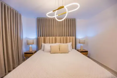 a bedroom with a large bed with a ceiling fan at Modern 3BR! 9fl, King Bed! Sti!, in Santiago de los Caballeros