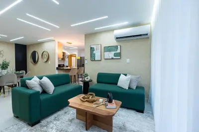 a living room with a green couch and a table at Modern 3BR! 9fl, King Bed! Sti!, in Santiago de los Caballeros
