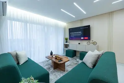 a living room with two green couches and a tv at Modern 3BR! 9fl, King Bed! Sti!, in Santiago de los Caballeros
