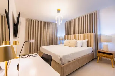 a bedroom with a bed and a desk with a lamp at Modern 3BR! 9fl, King Bed! Sti!, in Santiago de los Caballeros