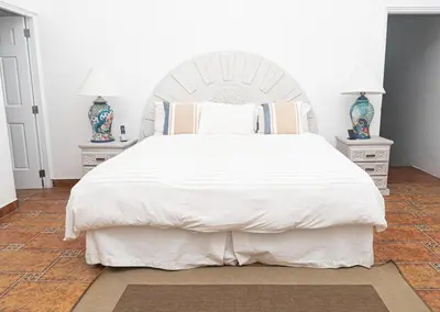 a bedroom with a large white bed with two night stands at Cacique 13, Ocean View and Golf Course in La Romana