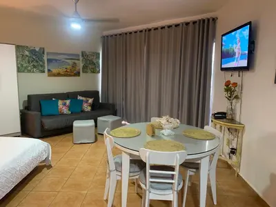 a living room with a table and chairs and a couch at Confortable vista al mar in Juan Dolio