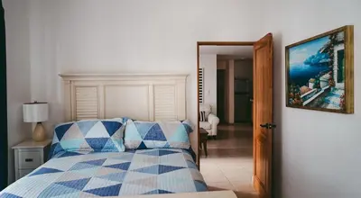 a bedroom with a blue and white bed and a mirror at 2BR 2BA Beachfront 63 in Bayahibe