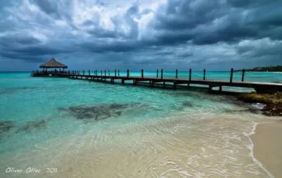 a pier in the water next to a beach at 2BR 2BA Beachfront 63 in Bayahibe