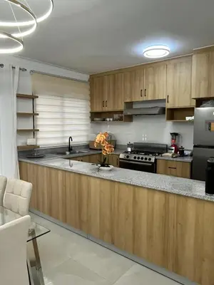 a kitchen with wooden cabinets and a counter top at Legado Edif V Apto A2 in Azua de Compostela