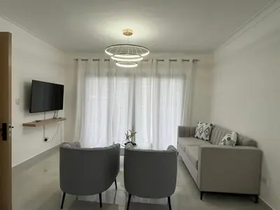 a living room with a couch and a tv at Legado Edif V Apto A2 in Azua de Compostela