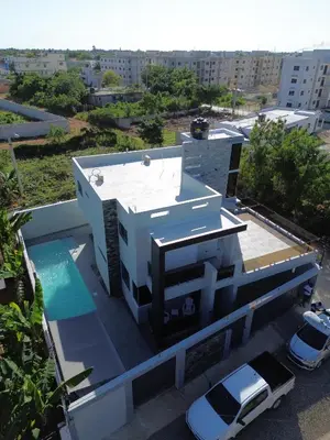 a white house with a car parked on the roof at Andys Villa in Naime 3 in San Pedro de Macorís