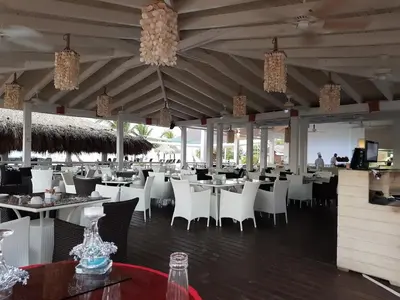 a dining room with white tables and chairs at 2BR 2BA Beachfront With View 62 in Bayahibe
